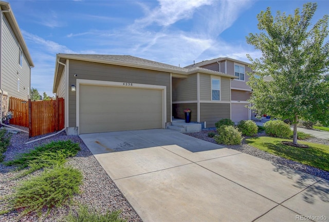 view of front of property with driveway, a garage, and fence