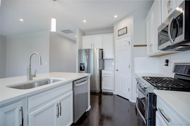 kitchen featuring pendant lighting, tasteful backsplash, white cabinetry, sink, and stainless steel appliances