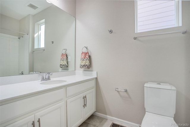 bathroom featuring vanity, toilet, tile patterned flooring, and a shower