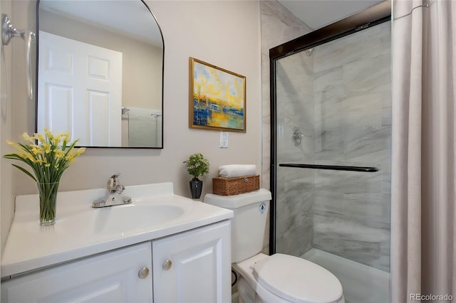 bathroom featuring vanity, toilet, and a shower with door