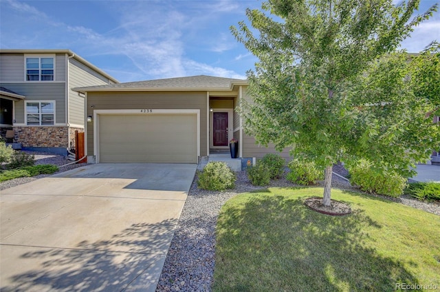 view of front of home featuring concrete driveway, an attached garage, and a front lawn