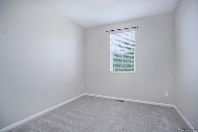 carpeted empty room featuring visible vents and baseboards