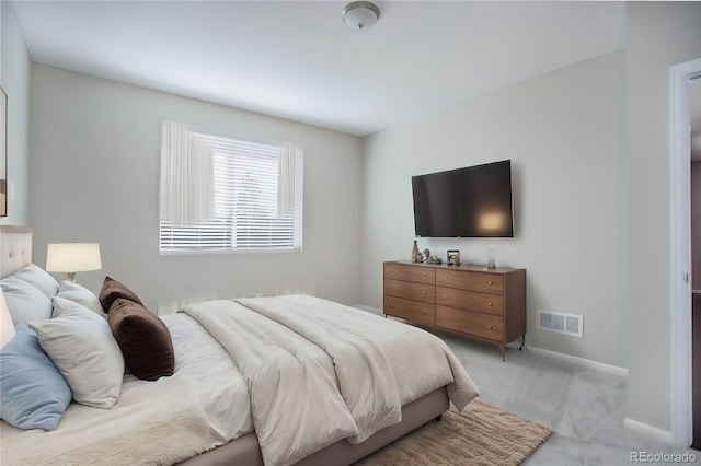 bedroom with baseboards, visible vents, and light carpet