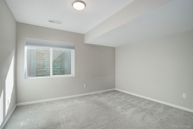 carpeted spare room featuring baseboards and visible vents