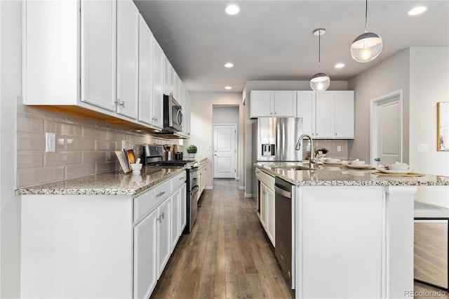 18815 W 93rd Ave, Arvada, CO 80007 - kitchen with appliances with stainless steel finishes, hardwood / wood-style floors, recessed lighting, a kitchen island with sink, and white cabinets