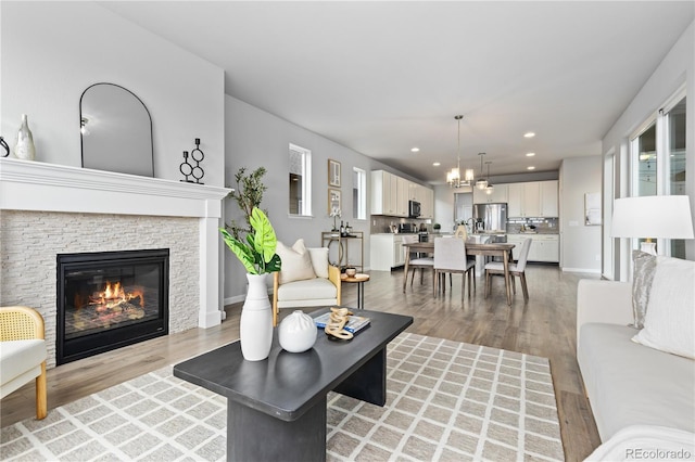 18815 W 93rd Ave, Arvada, CO 80007 - living room featuring light wood finished floors, a glass covered fireplace, plenty of natural light, and recessed lighting