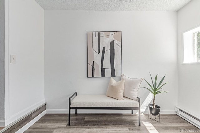 4450 S Fox St, Englewood, CO 80110 - living area featuring a baseboard heating unit, a textured ceiling, and wood finished floors