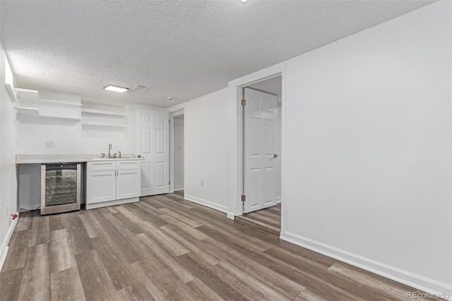 4450 S Fox St, Englewood, CO 80110 - indoor wet bar with beverage cooler, wood finished floors, and a textured ceiling