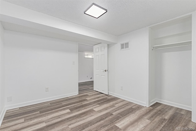 4450 S Fox St, Englewood, CO 80110 - unfurnished bedroom featuring wood finished floors, a textured ceiling, and a closet