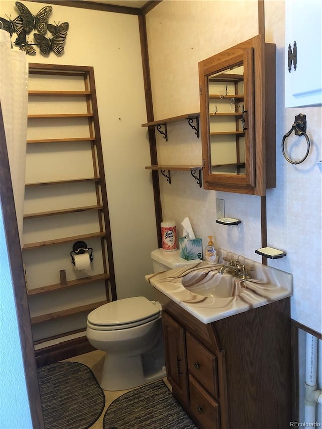 bathroom with tile patterned flooring, vanity, and toilet