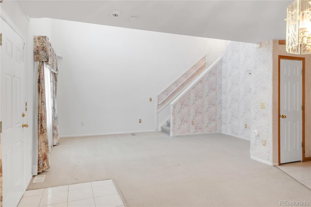 unfurnished living room featuring visible vents, stairway, carpet flooring, an inviting chandelier, and tile patterned floors