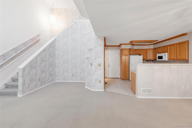 unfurnished living room with visible vents, ornamental molding, wallpapered walls, light colored carpet, and stairs