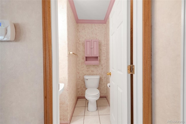 bathroom featuring tile patterned flooring, crown molding, toilet, and wallpapered walls