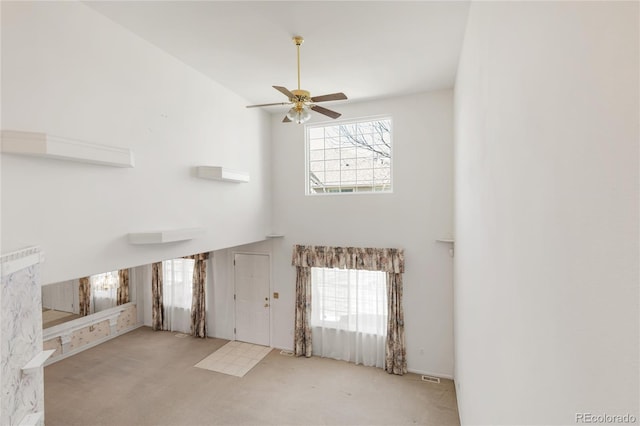 interior space with a wealth of natural light, a high ceiling, and ceiling fan