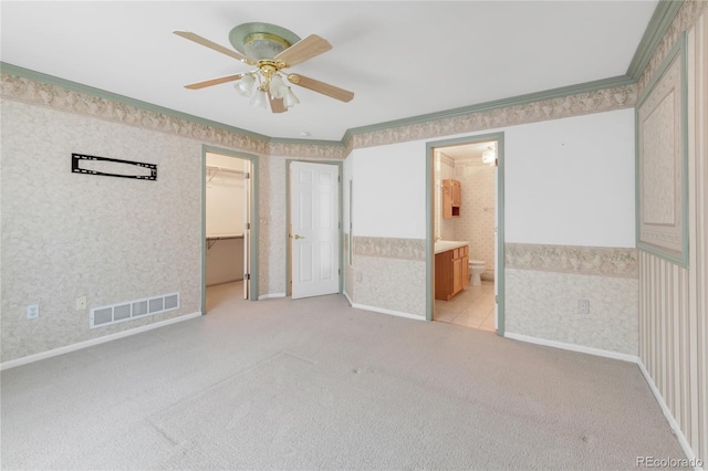 unfurnished bedroom featuring visible vents, light colored carpet, wallpapered walls, and ornamental molding