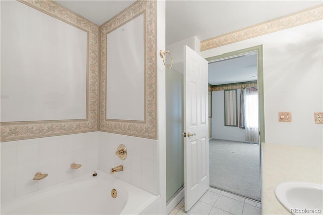 bathroom featuring wallpapered walls, a bath, tile patterned flooring, and a sink