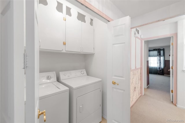 laundry room featuring cabinet space, light colored carpet, and washing machine and clothes dryer