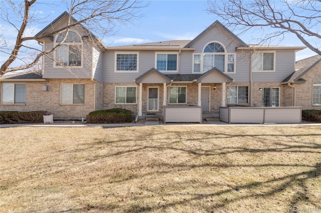 view of front facade with brick siding and a front yard