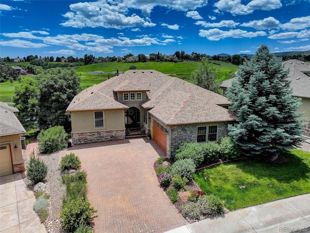 11208 W Ontario Ave, Littleton, CO 80127 - view of front facade featuring stone siding, an attached garage, stucco siding, and decorative driveway