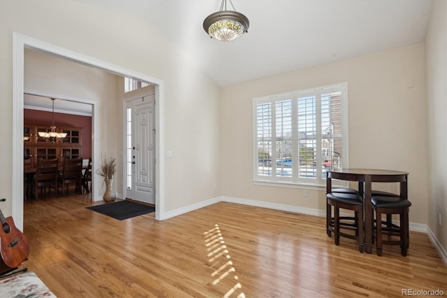 foyer with an inviting chandelier and hardwood / wood-style flooring