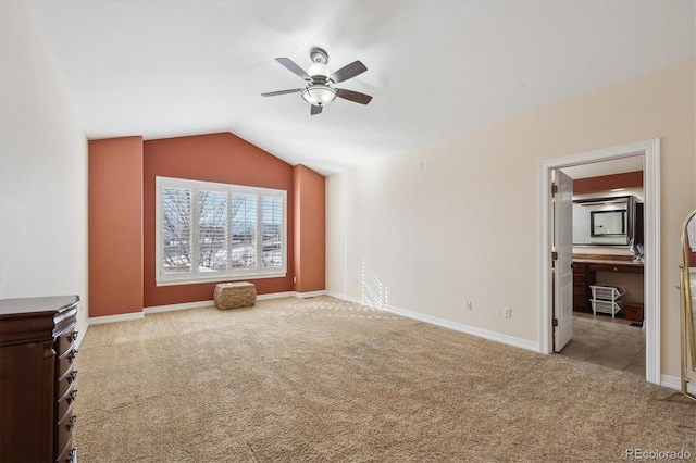 interior space with ceiling fan, lofted ceiling, and light carpet