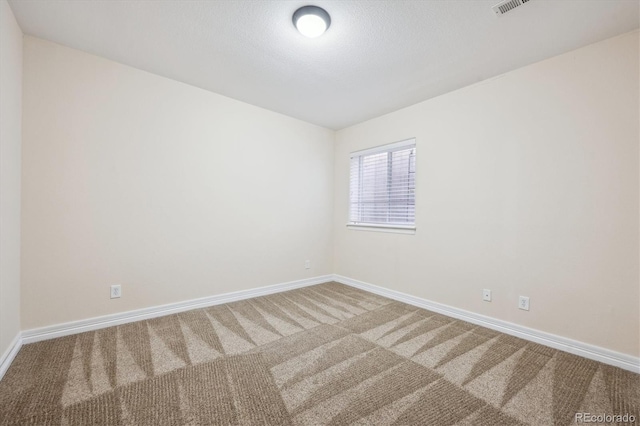 carpeted spare room featuring a textured ceiling