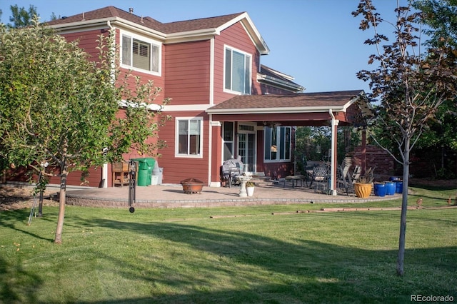 rear view of house featuring a fire pit, a patio area, and a lawn