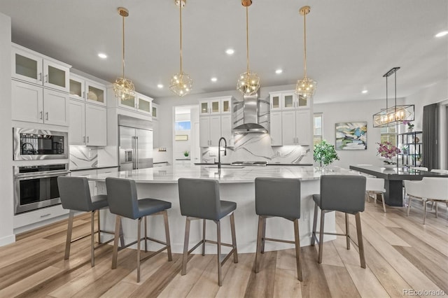 8023 Gore Creek Ln, Littleton, CO 80125 - kitchen with built in appliances, a sink, wall chimney range hood, recessed lighting, and tasteful backsplash