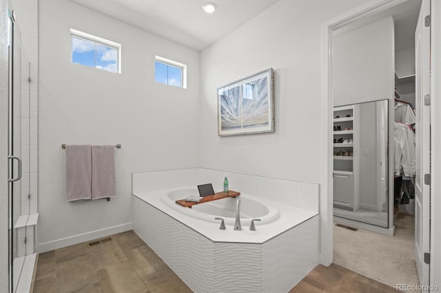 8023 Gore Creek Ln, Littleton, CO 80125 - full bath with a walk in closet, a garden tub, a stall shower, and baseboards