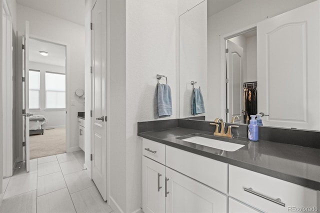 8023 Gore Creek Ln, Littleton, CO 80125 - bathroom featuring vanity, tile patterned floors, a walk in closet, and baseboards