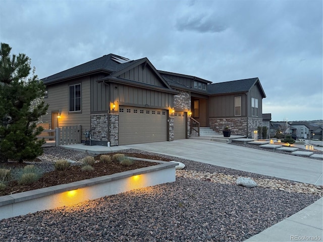 8023 Gore Creek Ln, Littleton, CO 80125 - view of front of property featuring board and batten siding, a garage, stone siding, and driveway