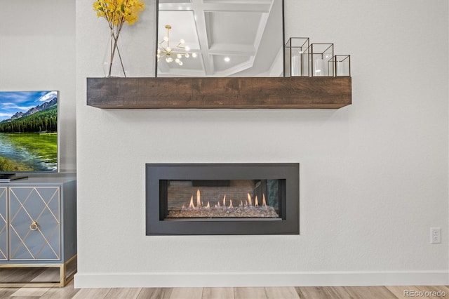 8023 Gore Creek Ln, Littleton, CO 80125 - detailed view of a chandelier, wood finished floors, baseboards, and a lit fireplace