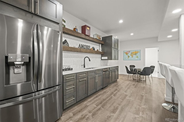 8023 Gore Creek Ln, Littleton, CO 80125 - kitchen featuring stainless steel appliances, open shelves, a sink, light countertops, and tasteful backsplash