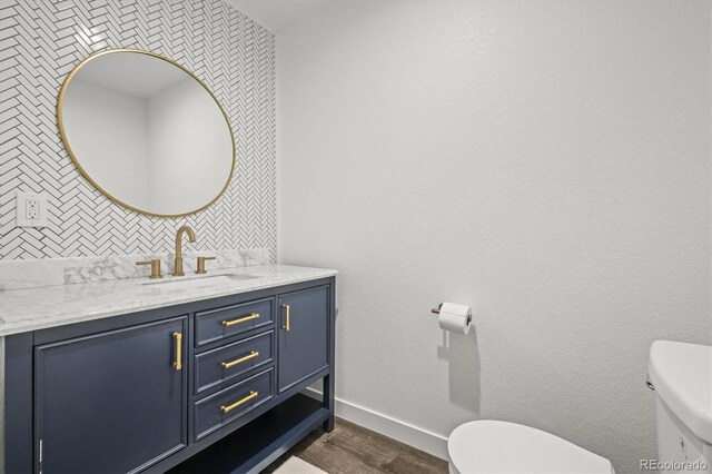 8023 Gore Creek Ln, Littleton, CO 80125 - half bathroom with toilet, vanity, wood finished floors, and baseboards