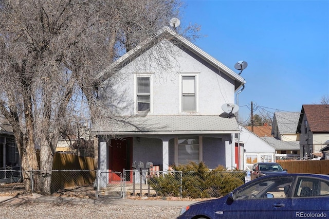 view of front of home with covered porch, a fenced front yard, a gate, and stucco siding