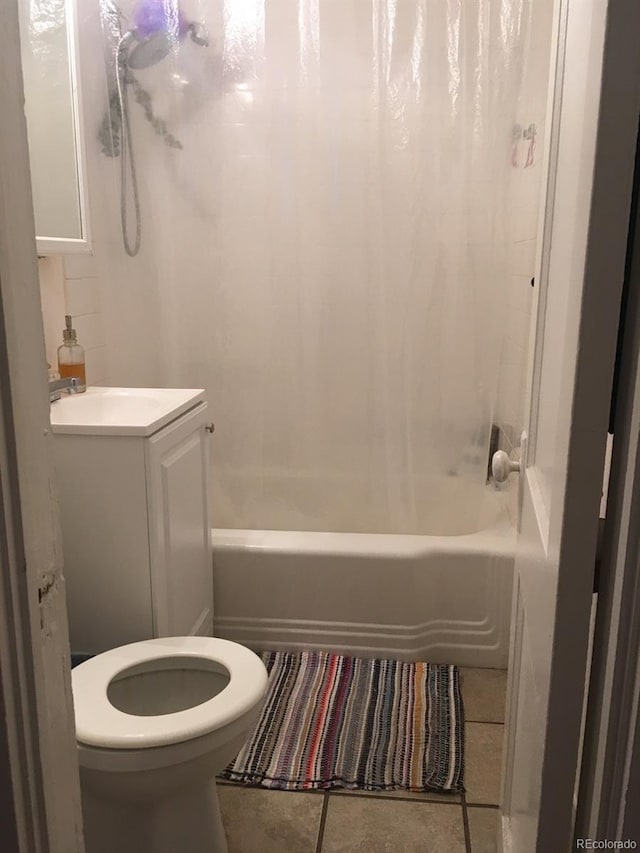 full bath featuring shower / bath combo with shower curtain, a sink, toilet, and tile patterned floors