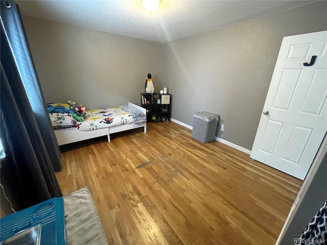 13660 Monroe St, Thornton, CO 80602 - bedroom featuring wood finished floors, a textured ceiling, and a textured wall