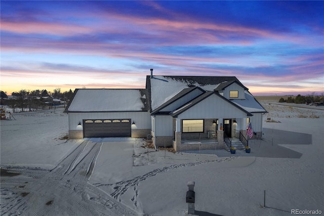 modern inspired farmhouse with a garage and covered porch