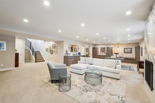 carpeted living room featuring a stone fireplace