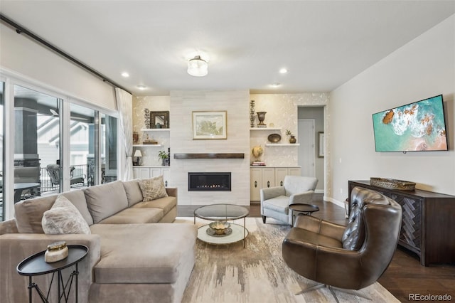 living room with a large fireplace, baseboards, recessed lighting, and wood finished floors