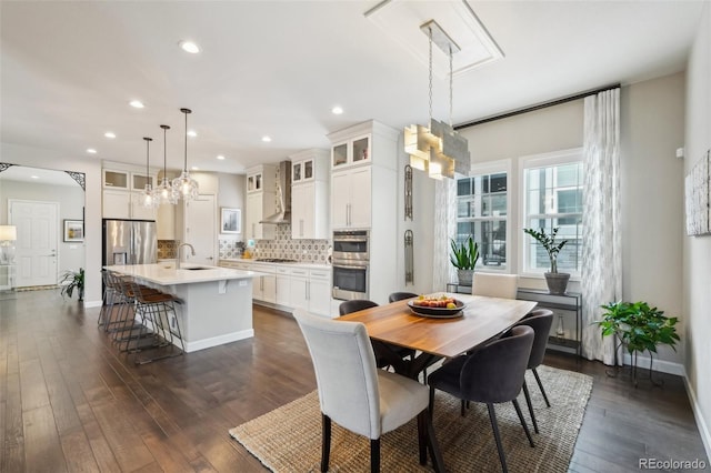 dining area with dark wood-style flooring, a notable chandelier, baseboards, and recessed lighting