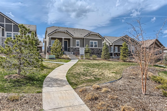 view of front facade with a front yard and stone siding