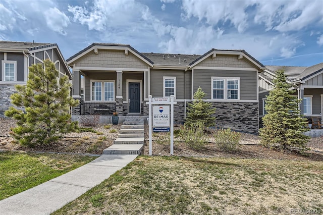 view of front of property with stone siding and covered porch