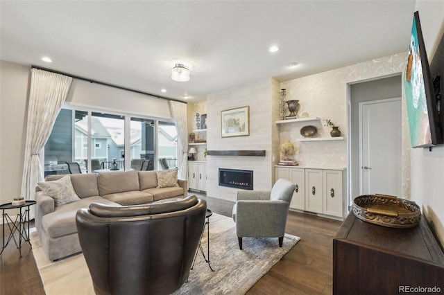 living area featuring a textured wall, recessed lighting, wood finished floors, and a tile fireplace