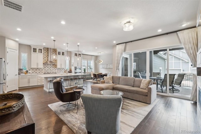 living room featuring wood finished floors, visible vents, and recessed lighting