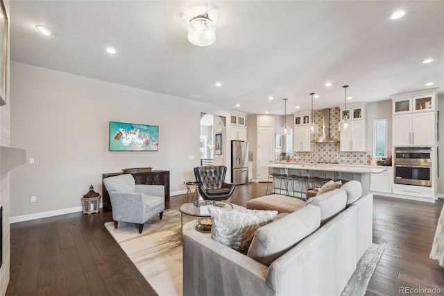 living room with baseboards, recessed lighting, and hardwood / wood-style flooring