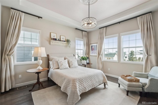 bedroom with wood finished floors, an inviting chandelier, baseboards, and visible vents