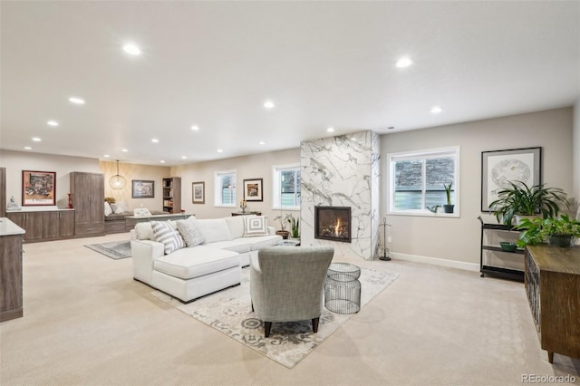 living room with light carpet, recessed lighting, baseboards, and a premium fireplace