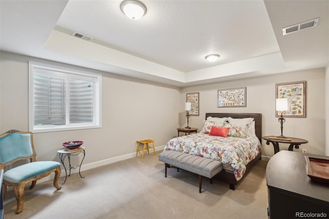 bedroom featuring visible vents, a raised ceiling, and carpet floors