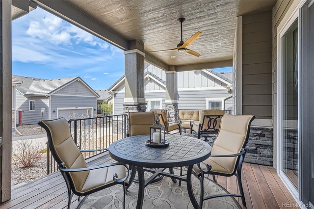 wooden terrace featuring outdoor lounge area, ceiling fan, and an outdoor structure